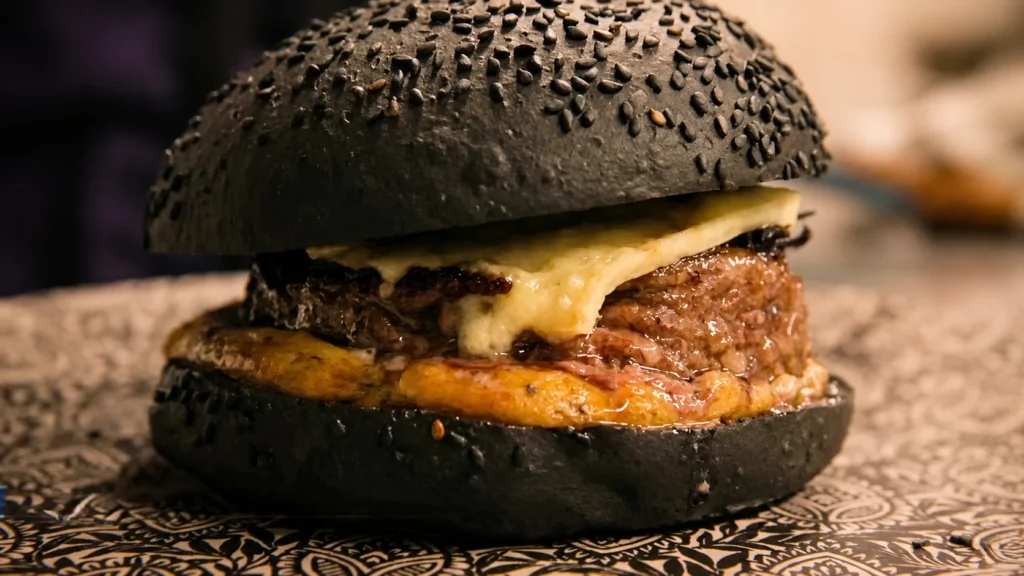 gros plan sur le burger noir dressé avec le fromage fondu